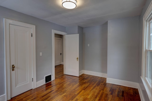 unfurnished bedroom featuring dark hardwood / wood-style flooring