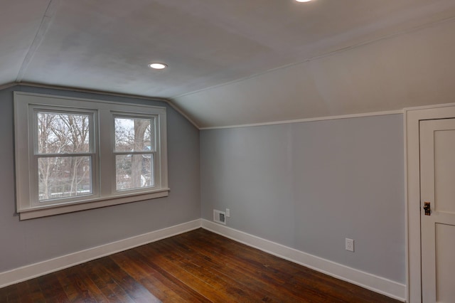 bonus room with dark hardwood / wood-style floors and vaulted ceiling