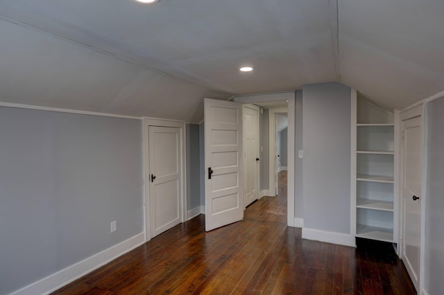 additional living space featuring dark wood-type flooring, built in features, and lofted ceiling