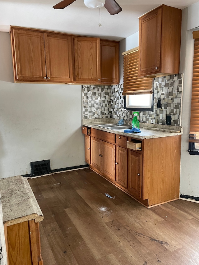 kitchen featuring ceiling fan, dark hardwood / wood-style flooring, backsplash, and sink