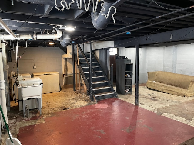 basement featuring refrigerator and washing machine and clothes dryer