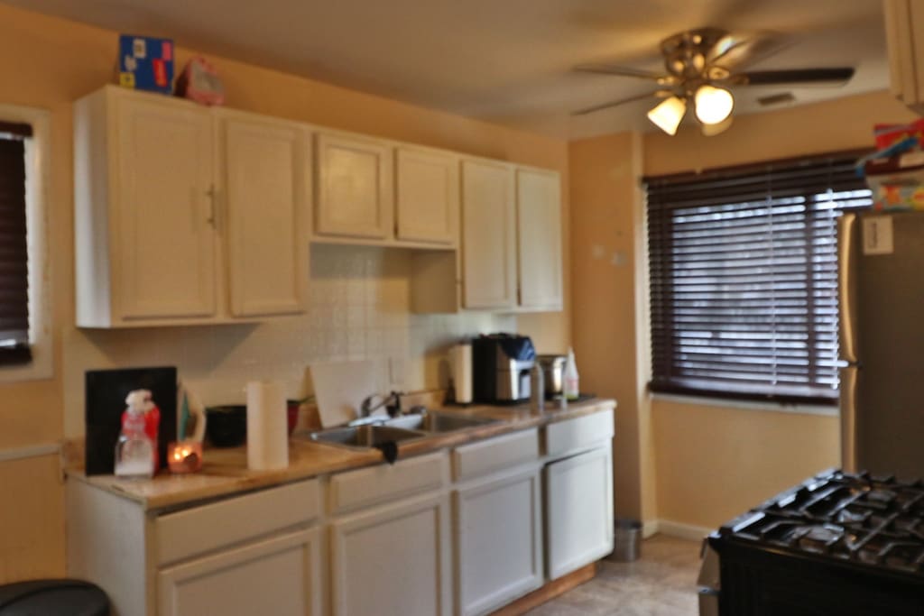 kitchen with ceiling fan, white cabinets, sink, and gas range