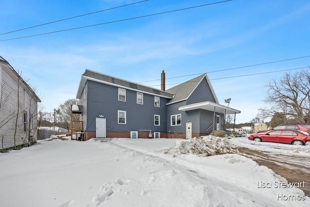 snow covered house with central AC unit