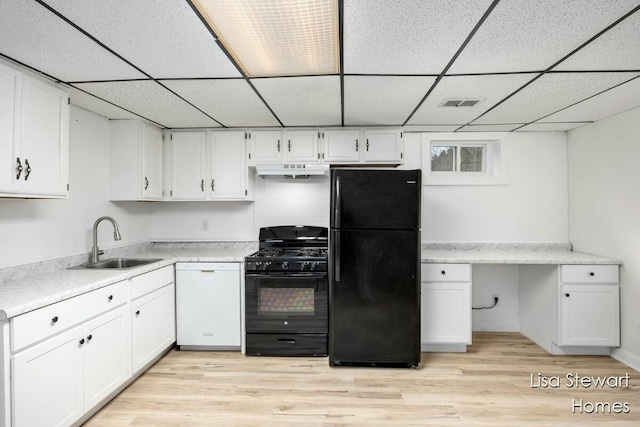 kitchen with white cabinetry, a paneled ceiling, black appliances, light hardwood / wood-style flooring, and sink