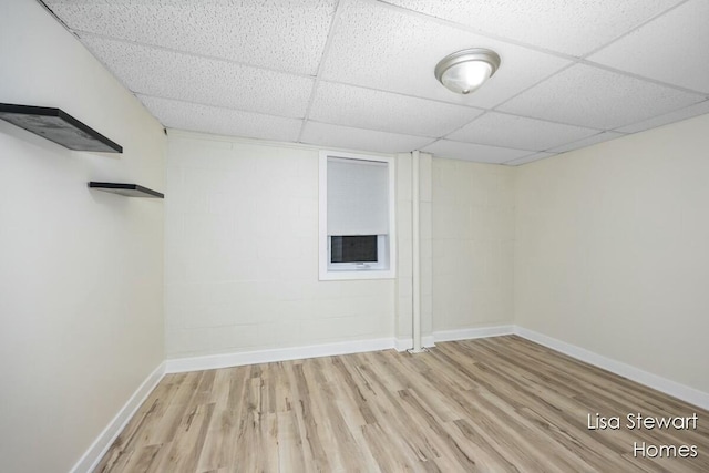 unfurnished room with a paneled ceiling and light hardwood / wood-style floors