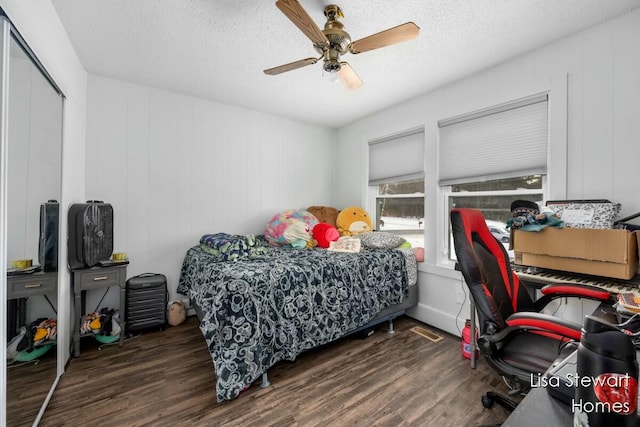 bedroom featuring ceiling fan, a closet, dark hardwood / wood-style flooring, and a textured ceiling