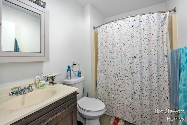 bathroom with toilet, vanity, and a shower with curtain