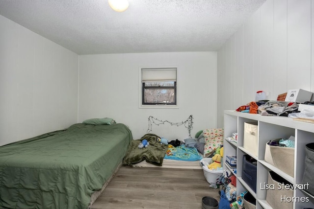 bedroom with a textured ceiling and light hardwood / wood-style flooring