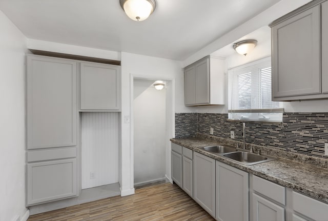 kitchen with gray cabinetry, tasteful backsplash, and sink