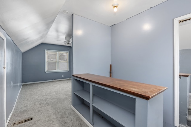 corridor with lofted ceiling and light colored carpet