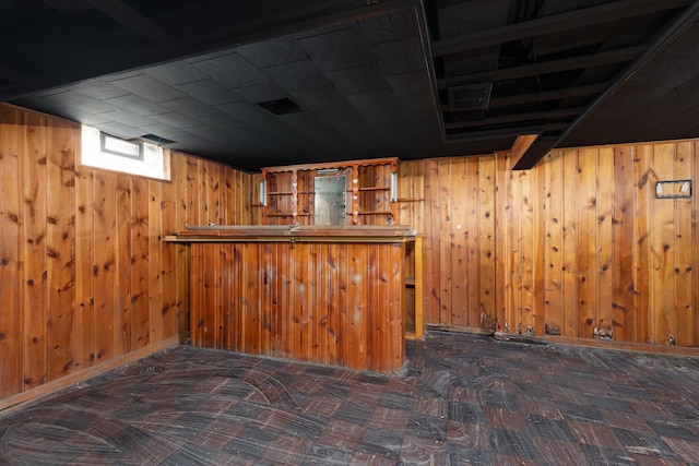 basement with bar area and wood walls