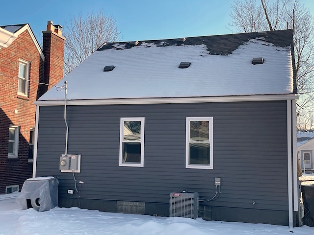 snow covered rear of property with cooling unit