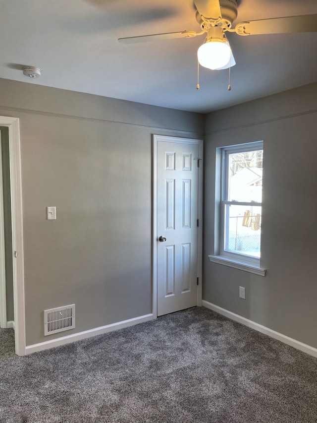 carpeted spare room with ceiling fan