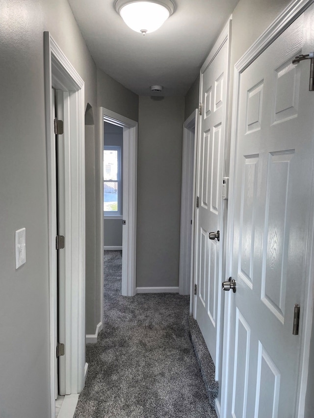 hall with dark colored carpet