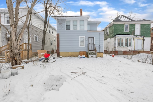 view of snow covered back of property