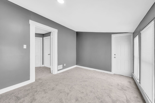 empty room featuring lofted ceiling and light colored carpet