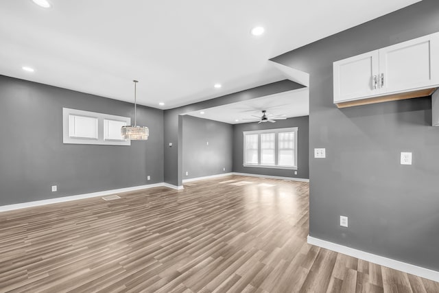 unfurnished living room featuring ceiling fan and light hardwood / wood-style flooring