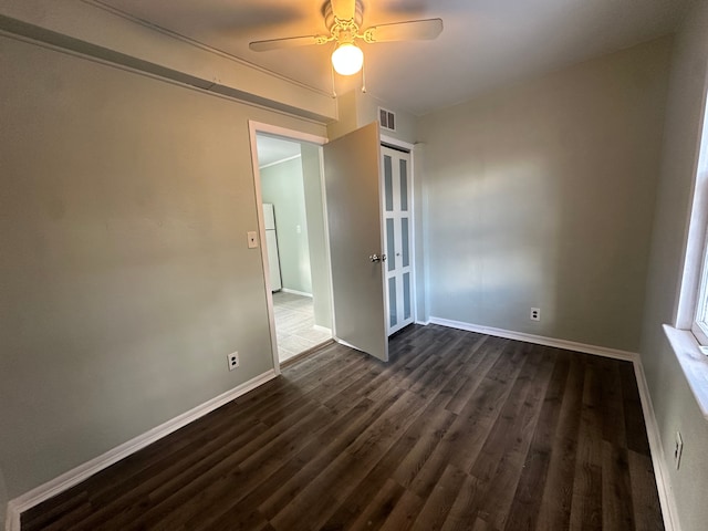 empty room with ceiling fan and dark hardwood / wood-style floors