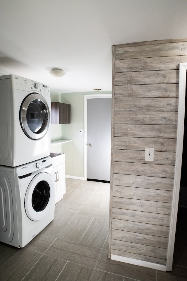 washroom featuring cabinets and stacked washer / drying machine