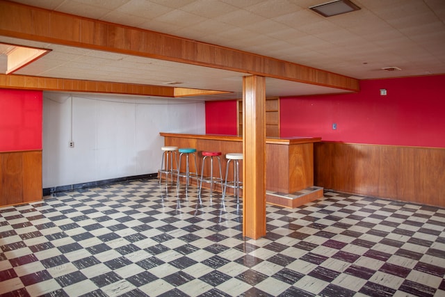 basement with wood walls and bar area