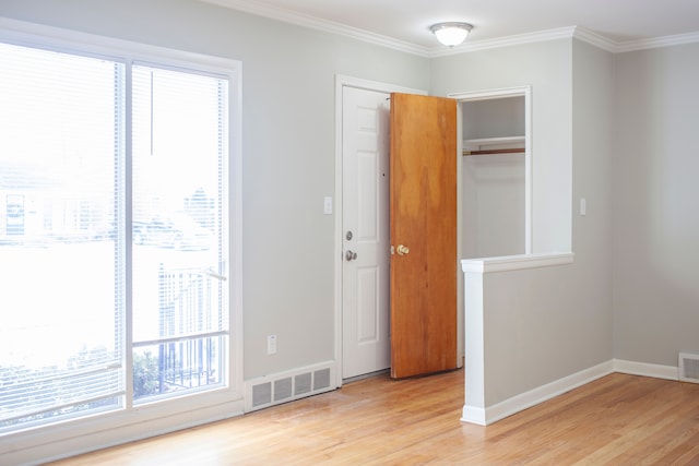 interior space with a closet, light hardwood / wood-style flooring, and ornamental molding