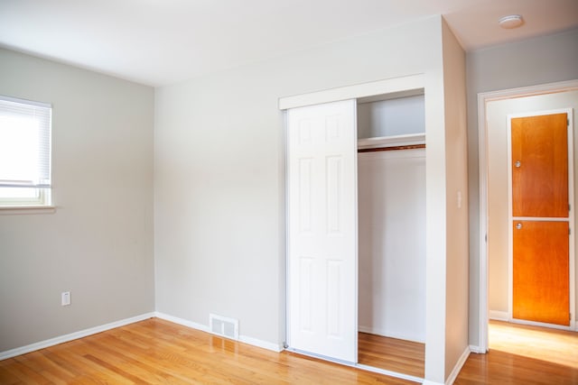 unfurnished bedroom featuring hardwood / wood-style floors and a closet