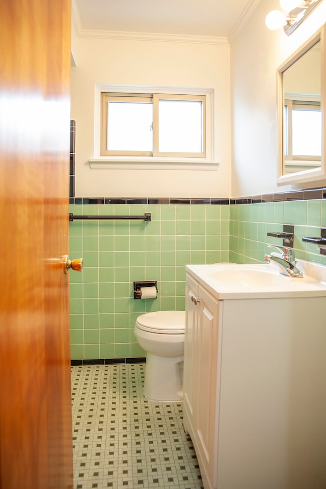 bathroom with vanity, toilet, tile walls, and crown molding