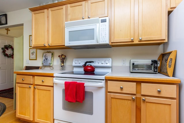 kitchen with white appliances and light brown cabinets