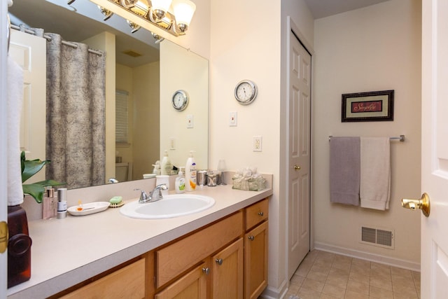 bathroom with toilet, tile patterned flooring, and vanity