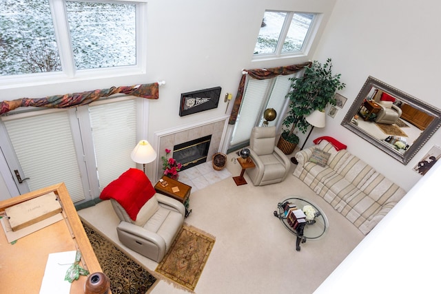 carpeted living room with a high ceiling and a tile fireplace