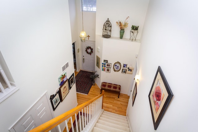 hallway featuring light hardwood / wood-style floors and a high ceiling