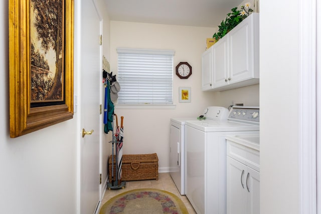 laundry room with light tile patterned floors, washer and dryer, and cabinets