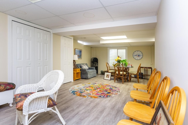 living area featuring a paneled ceiling and hardwood / wood-style flooring