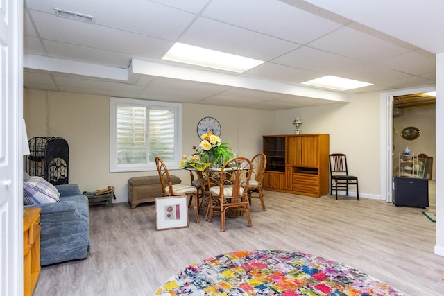 interior space with a paneled ceiling and hardwood / wood-style flooring