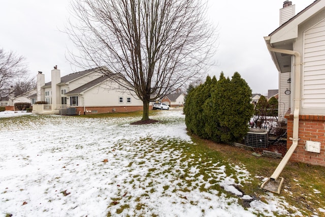 snowy yard featuring central AC