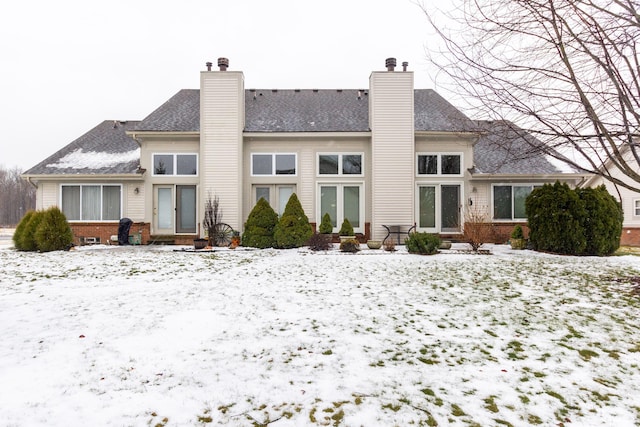 view of snow covered rear of property