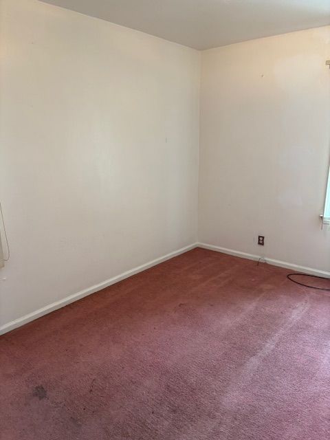 spare room with carpet flooring and baseboards