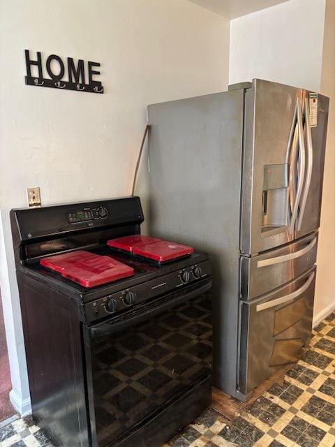 detailed view of black electric range and stainless steel fridge