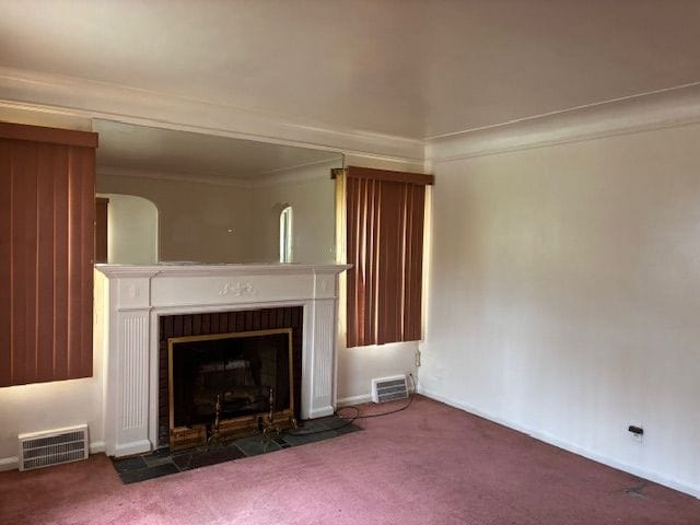 unfurnished living room featuring a fireplace with flush hearth, carpet, and baseboards
