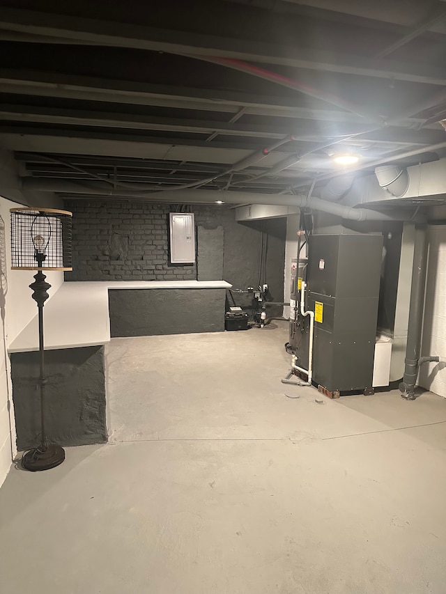 unfinished below grade area with electric panel and heating unit