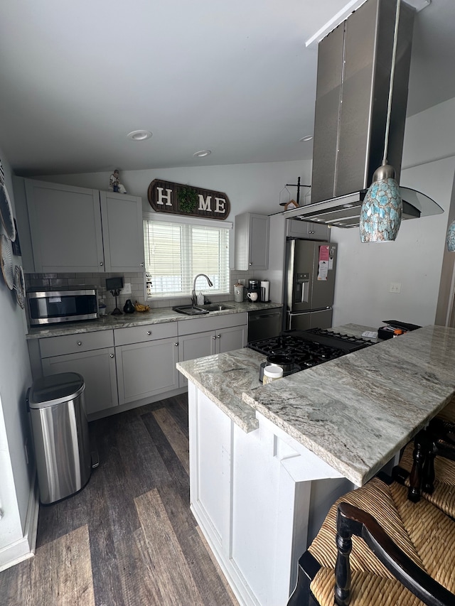 kitchen featuring lofted ceiling, sink, appliances with stainless steel finishes, island exhaust hood, and light stone countertops