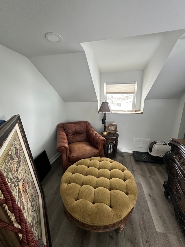 sitting room featuring baseboards, vaulted ceiling, and wood finished floors