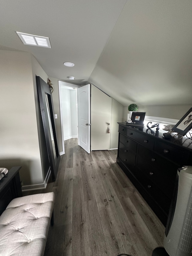 interior space with vaulted ceiling, dark wood-style flooring, and visible vents