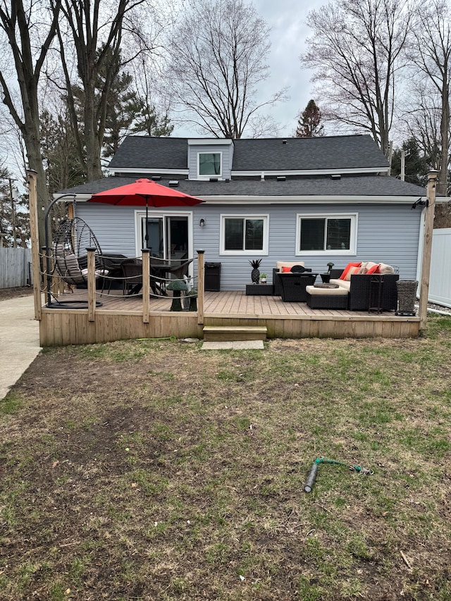 back of property with a wooden deck, outdoor lounge area, fence, and roof with shingles