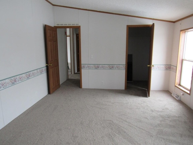 unfurnished bedroom with light colored carpet, a textured ceiling, and a closet