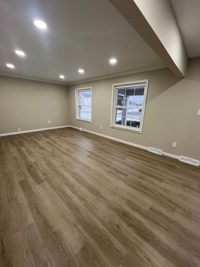 empty room with dark wood-type flooring and ornamental molding