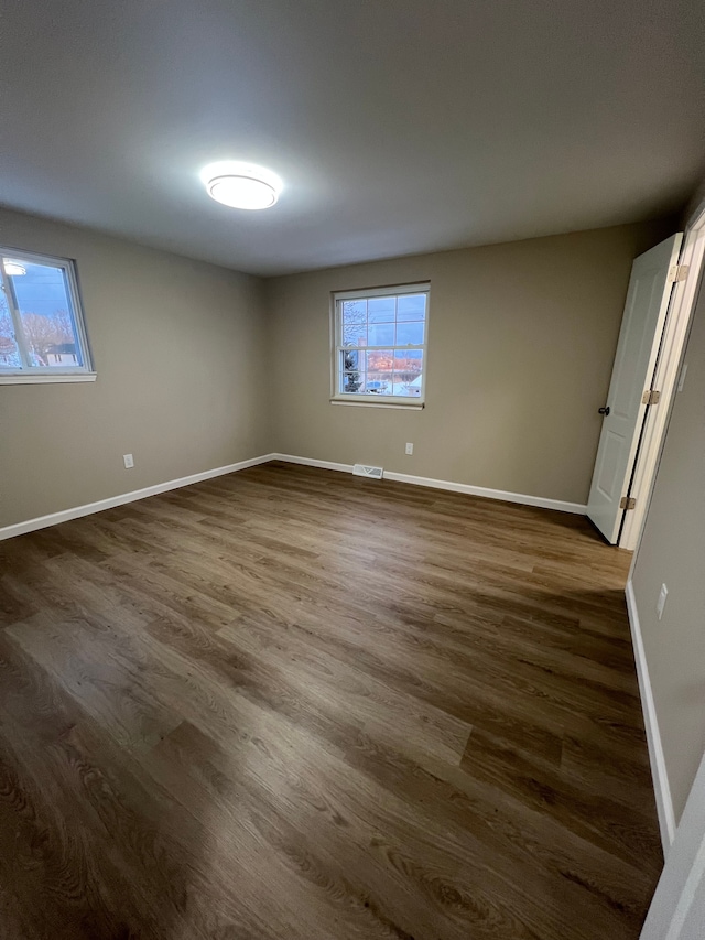 empty room with dark hardwood / wood-style flooring