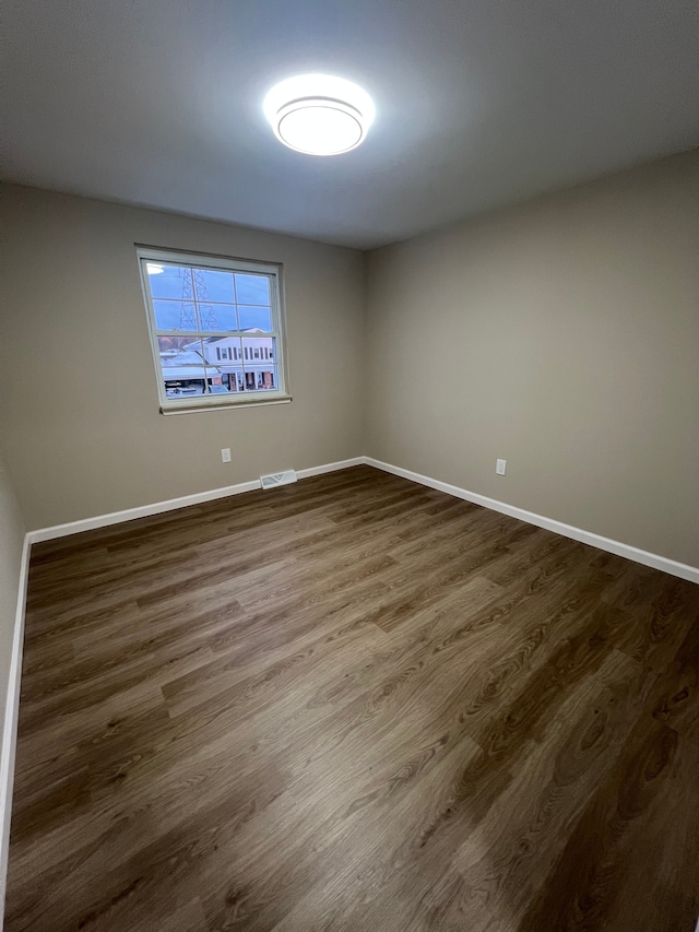 empty room featuring dark hardwood / wood-style flooring