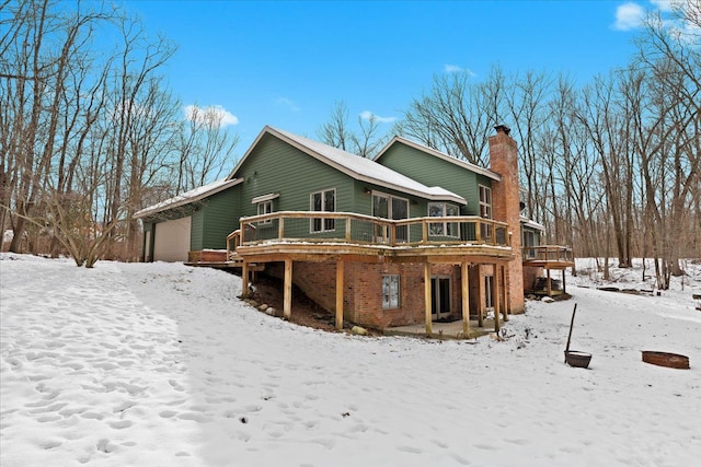 snow covered house with a wooden deck