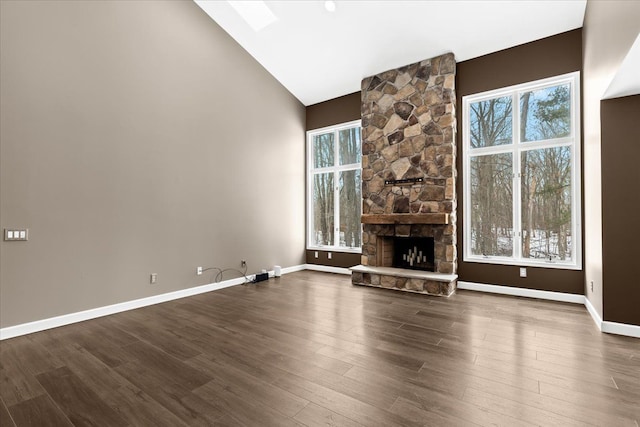 unfurnished living room featuring dark wood-type flooring, a fireplace, and a wealth of natural light